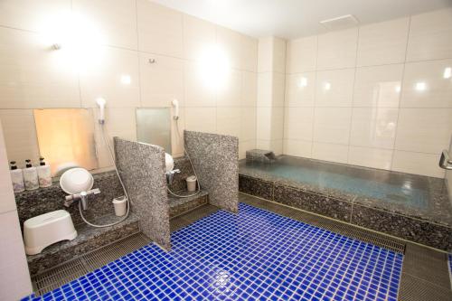 a bathroom with a tub and a toilet and a sink at Kuretake Inn Premium Fujinomiya in Fujinomiya