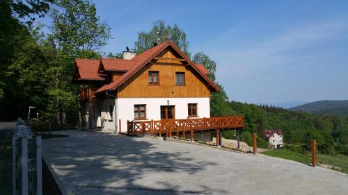 a house with a wooden roof on a road at Uroczysko starych sztolni in Szklarska Poręba
