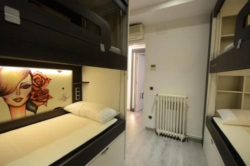 a bedroom with a bed with a painting on the wall at Free Hostels Barcelona in Barcelona