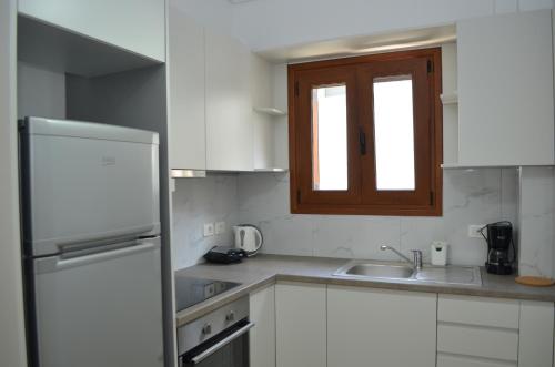 a kitchen with a white refrigerator and a sink at Saranda View Apartments in Sarandë