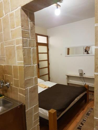a small room with a bed and a sink at Belette Apartments & Park in Nikšić