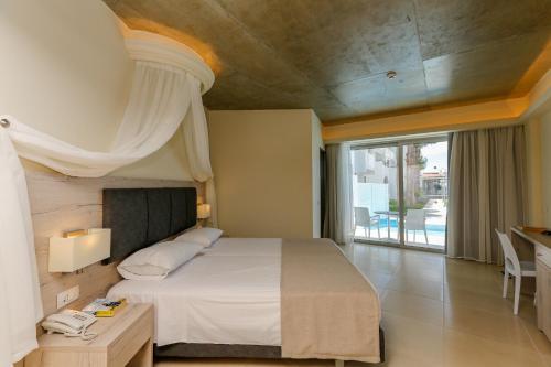 a bedroom with a large bed and a large window at Rodos Star Hotel in Afantou