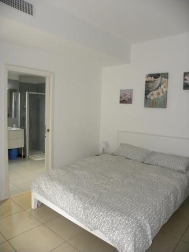 - une chambre blanche avec un lit et une salle de bains dans l'établissement Secret Garden, à Cannes