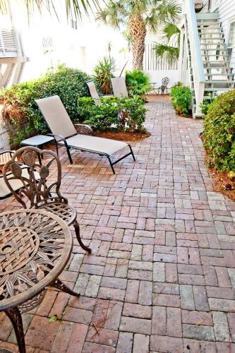 a patio with two chairs and a table and benches at DeSoto Beach Gardens in Tybee Island