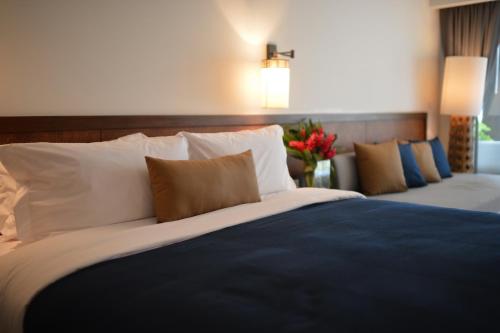 a bedroom with two beds with pillows and flowers at Southsea Khaolak Beach Resort - Soft Opening in Khao Lak