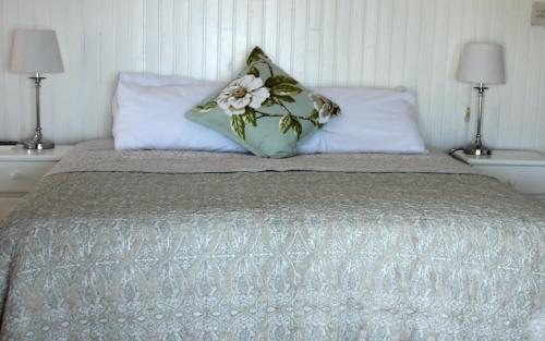 a bed with two lamps and two pillows on it at Gill's Beach House in Chintsa