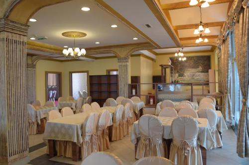 a banquet hall with white tables and chairs at Hotel & Restaurant Great Wall - Airport in Sarajevo