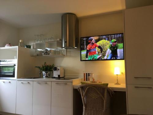a kitchen with a tv hanging on the wall at Landhausvilla Strittberg 7 in Höchenschwand