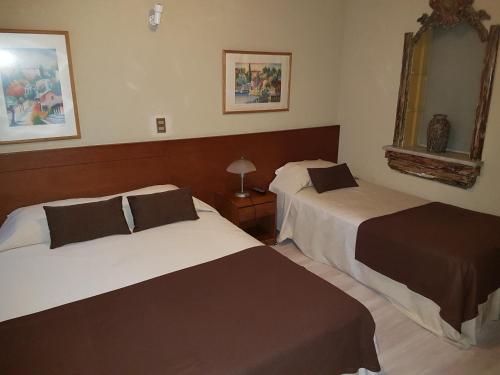 a hotel room with two beds and a mirror at Hotel 5 Norte in Viña del Mar