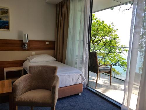 Habitación de hotel con cama y balcón en Boutique Hotel Mali Raj en Opatija