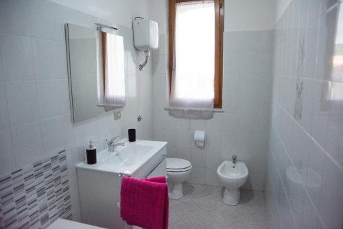 a white bathroom with a sink and a toilet at Pretty Appartment Beb in Alghero