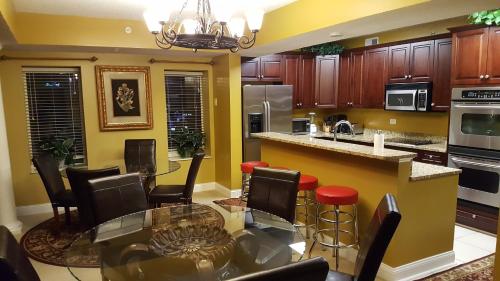 a large kitchen with a glass table and chairs at JeffsCondos - 5 Bedroom - Ocean Blue Resort in Myrtle Beach