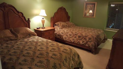 a bedroom with two beds and a lamp on a night stand at JeffsCondos - 5 Bedroom - Ocean Blue Resort in Myrtle Beach