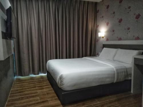 a hotel room with a bed and a television at Kampar Boutique Hotel (Kampar Sentral) in Kampar