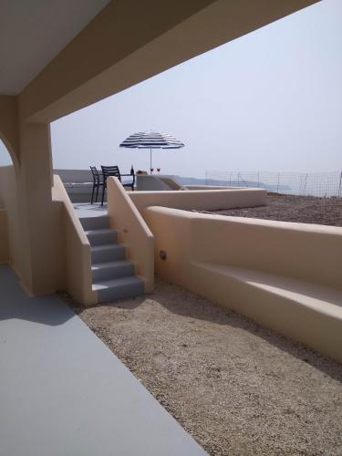 a staircase leading to the beach with an umbrella at Santa Rinoula Suites Sea Sunset views Adults only in Megalokhori