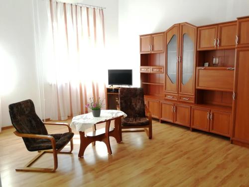 クドヴァ・ズドゥルイにあるApartament Jaśminowyのリビングルーム(木製家具、テーブル、椅子付)