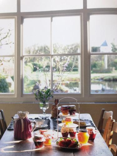a table with breakfast food on it with windows at Bed & Breakfast Het Zilte Zand - luxe ontbijt - gratis parking - Westende Middelkerke in Middelkerke