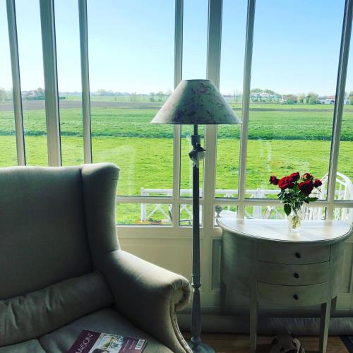 a living room with a couch and a table with a lamp at Bed & Breakfast Het Zilte Zand - luxe ontbijt - gratis parking - Westende Middelkerke in Middelkerke
