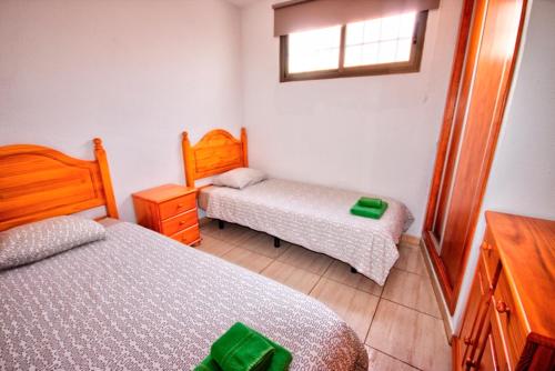 プラヤ・デル・イングレスにあるApartamento al lado de la playaの小さなベッドルーム(ベッド2台、窓付)