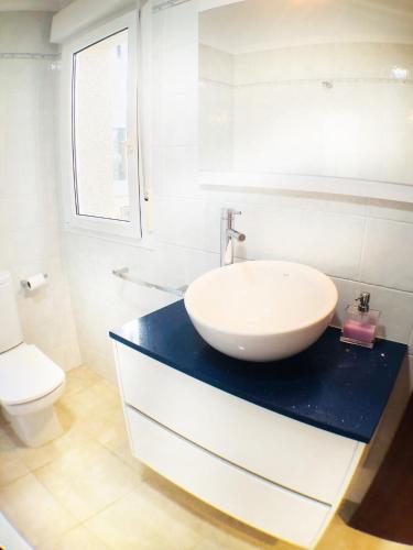 a white bathroom with a sink and a toilet at the Beach House in A Pobra do Caramiñal