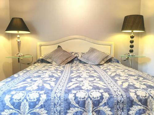 a bedroom with a blue and white bed with two lamps at La Dolce Vita Abbazia in Opatija