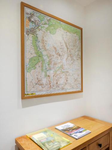 a map hanging on a wall above a wooden table at Tower Ridge Courtyard in Fort William