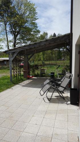 a patio with a bench and a wooden shelter at Apartamenty Oaza in Rewal