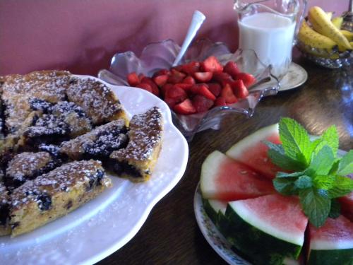 a table topped with plates of food and fruit at Benjamin F. Packard House Bed and Breakfast in Bath