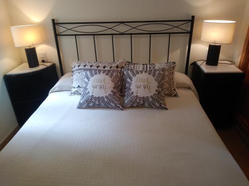 una camera da letto con un letto con cuscini sopra di Ada Edison Apartamento, Parking, Aire acondicionado, WiFi, Piscinas a Peñíscola