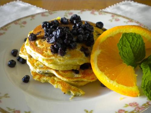 a plate of pancakes with blueberries and an orange slice at Benjamin F. Packard House Bed and Breakfast in Bath