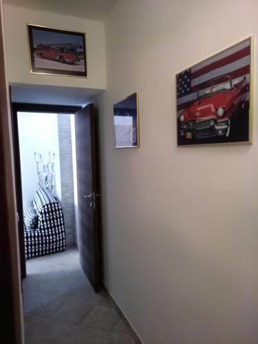 a hallway with two pictures of a car on the wall at Holiday House Marlin in Giardini Naxos