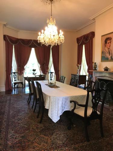 Canemount Plantation Inn في Westside: غرفة طعام مع طاولة مع كراسي وثريا