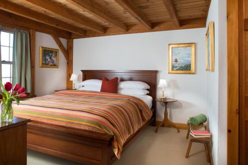 a bedroom with a bed, a desk, and a window at Seven Sea Street Inn in Nantucket