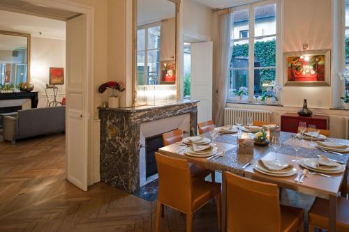 uma sala de jantar com uma mesa e uma lareira em Maison d'Hôte de Myon em Nancy