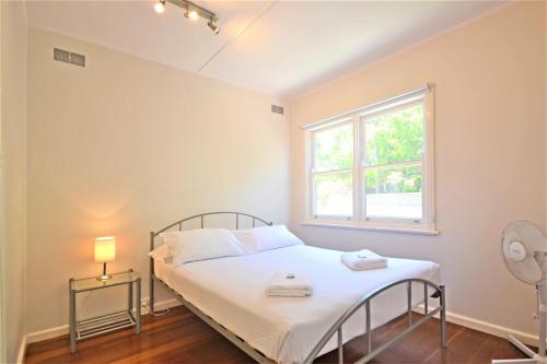 a small bedroom with a bed and a window at Breakers 5 2 Hill Street in Port Macquarie