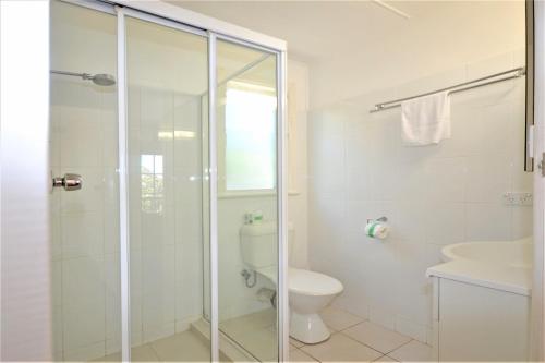 a bathroom with a shower and a toilet and a sink at Breakers 5 2 Hill Street in Port Macquarie