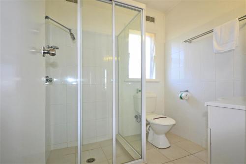 a bathroom with a shower and a toilet at Breakers 6 2 Hill Street in Port Macquarie