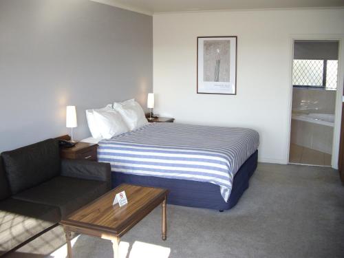 a hotel room with a bed and a couch at Best Western Plus The Tudor Box Hill in Box Hill