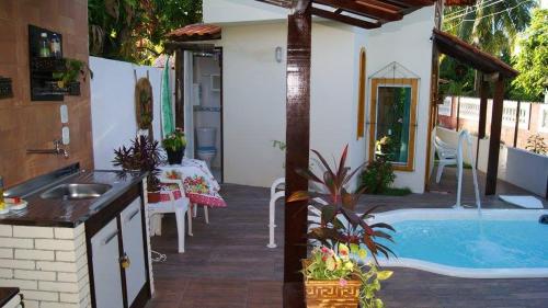 Cette maison dispose d'une piscine et d'une cuisine avec un évier. dans l'établissement Chalé Morada dos Sonhos, à Vera Cruz de Itaparica