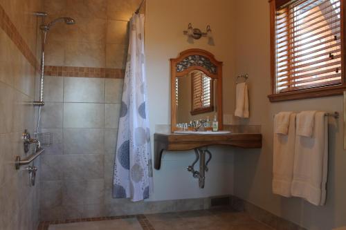 a bathroom with a shower and a sink and a mirror at Gîte Vita Bella B&B in Saint Adolphe D'Howard