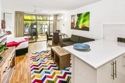 a kitchen and living room with a couch and a table at Cascade Gardens in Cairns