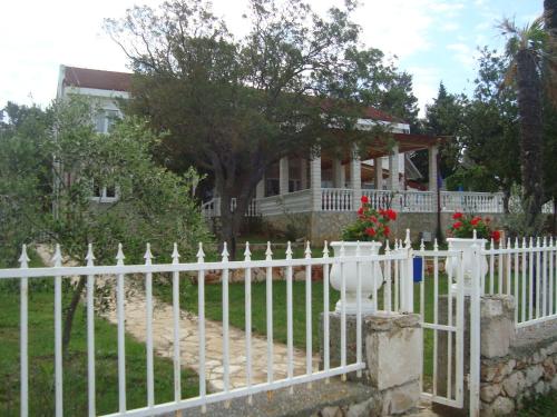 a white picket fence in front of a house at Vila Punta in Šibuljina