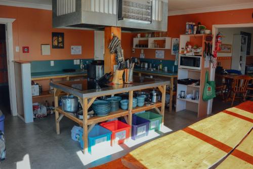 una cocina con paredes de color naranja y una barra con platos en Blue Moon Lodge, en Havelock