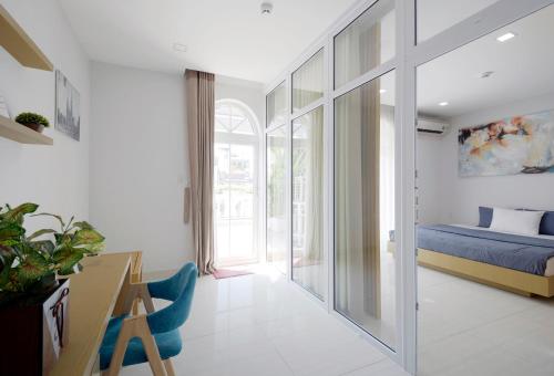 a bedroom with a bed and a desk in a room at Babylon D3 Serviced Apartment in Ho Chi Minh City