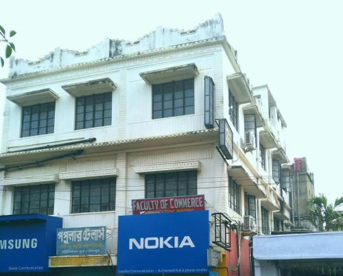 un edificio blanco con un cartel en el costado en Chaiti Lodge - Santiniketan Bolpur en Bolpur