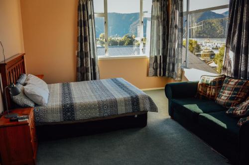 a bedroom with a bed and a couch and a window at Blue Moon Lodge in Havelock