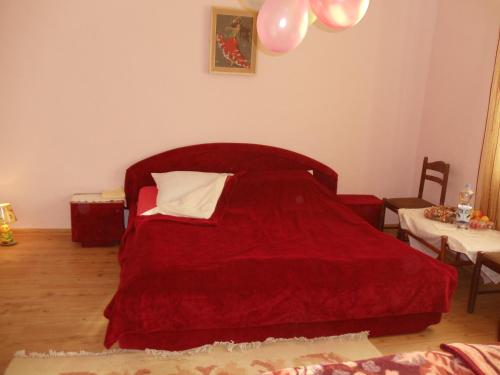 a bedroom with a bed with a red bedspread at Kaktus in Kaluđerovo