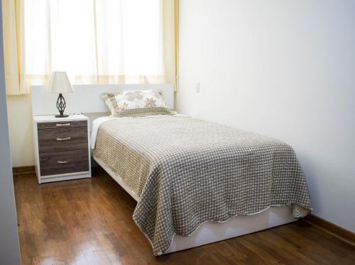 1 dormitorio con 1 cama, vestidor y ventana en San Isidro apartment en Lima