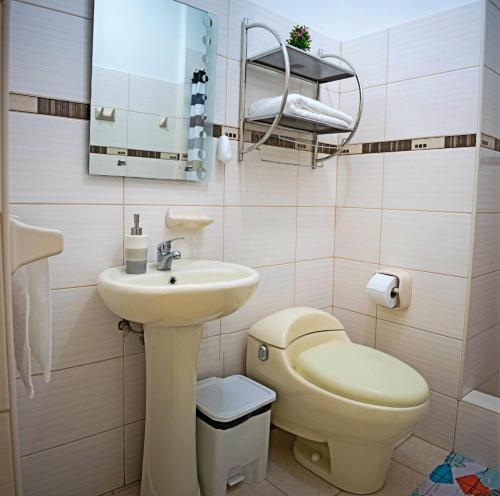 y baño con lavabo, aseo y espejo. en San Isidro apartment, en Lima