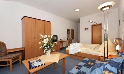 a hospital room with two beds and a table and chairs at Landhotel Tannenhof in Spiegelau
